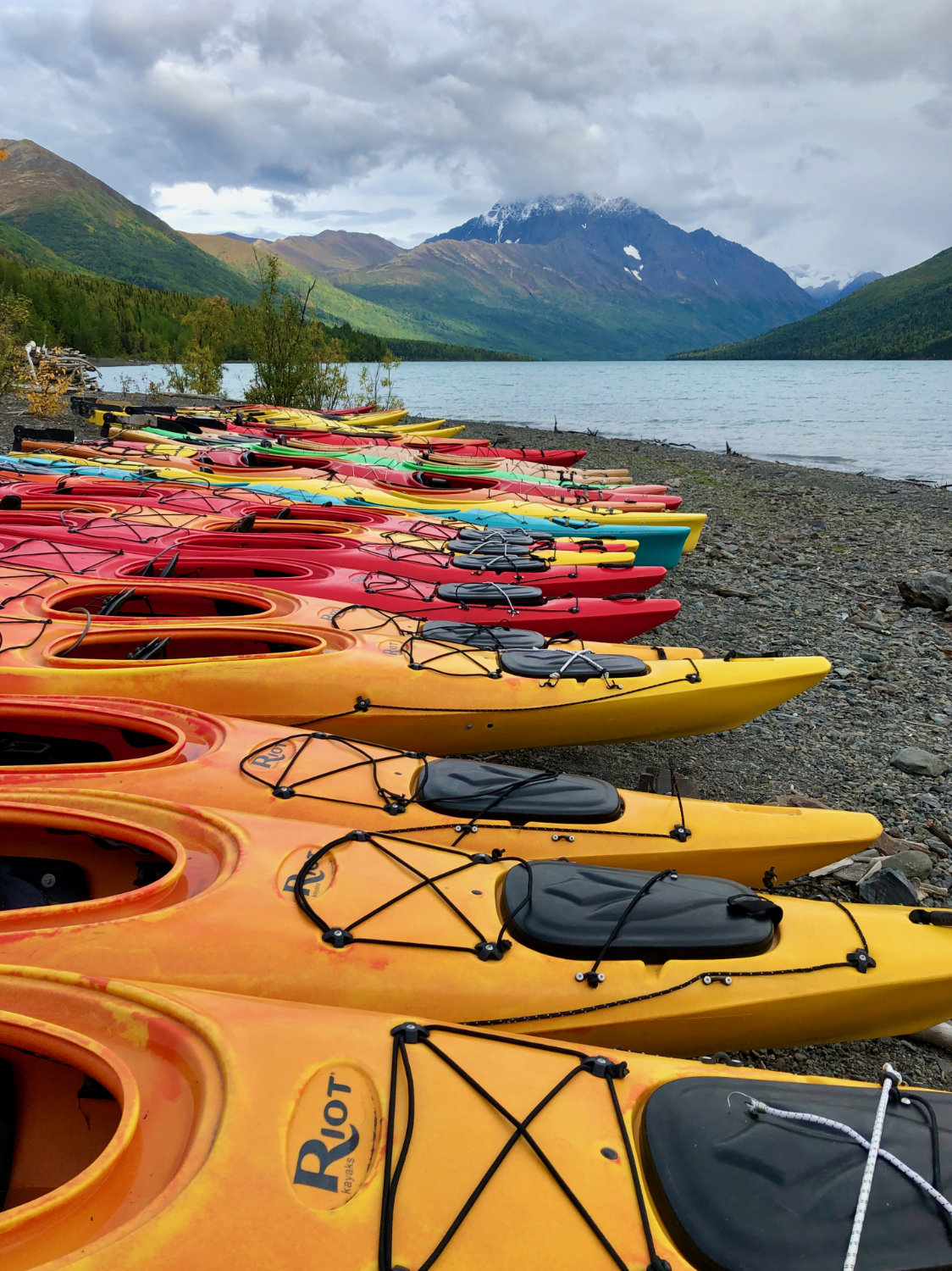 Kayaks lined up along the shore of Ekluta Lake in Alaska