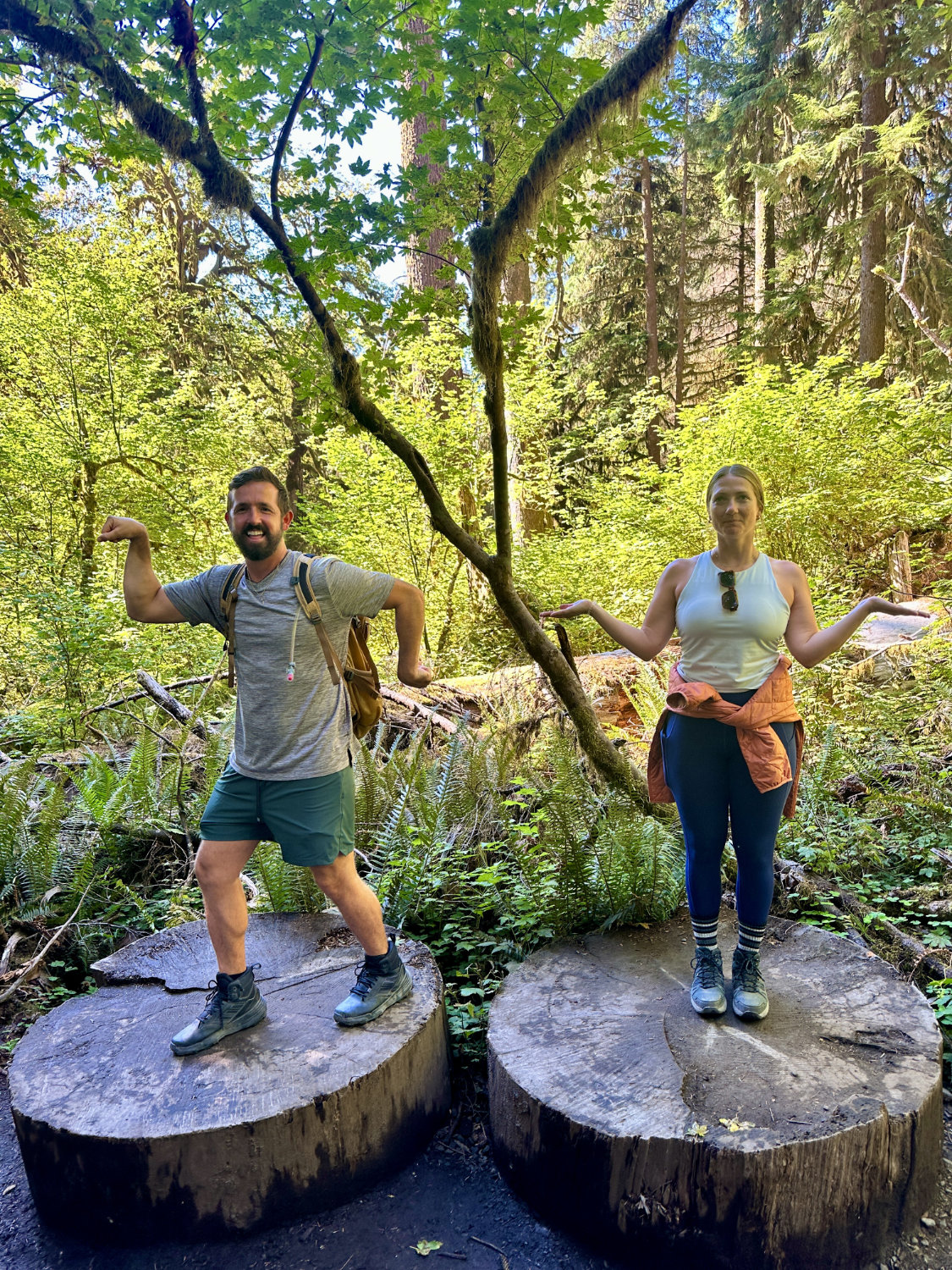 Grant and Michelle posing on cut down tree trunks in the Hoh Rainforest in Olympic National Park